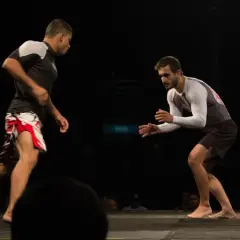 Two fighters face off, their stances showing the endurance and stamina required for this intense grappling match.