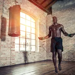 A boxer jumps rope in a brick gym. Jump rope is good for boxing because it builds stamina, agility, and footwork.