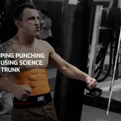 A boxer with chiseled boxer abs, mid-punch, in a gym. Text overlay: "Developing Punching Power Using Science: Part 2, Trunk.