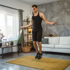 Man doing jump rope workout at home, a great alternative to burpees for cardio.
