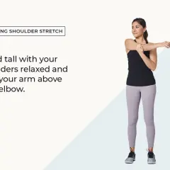Woman performing standing shoulder stretches, holding one arm across her chest.