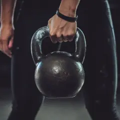 A person's hand grips a kettlebell, ready for a powerful kettlebell boxing workout.