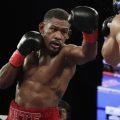 Jacobs boxer, Daniel Jacobs, throws a punch during a boxing match, sweat glistening on his muscular physique.