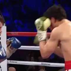 Two Mexican boxers clash in the ring. One, with blue gloves, faces his opponent who is blocking a punch with a green glove.