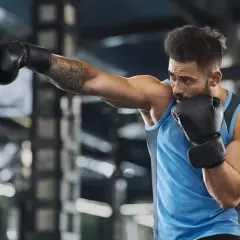 A boxer trains intensely, punching a heavy bag. This workout is a great way to see how many calories does boxing burn, boosting fitness and strength.