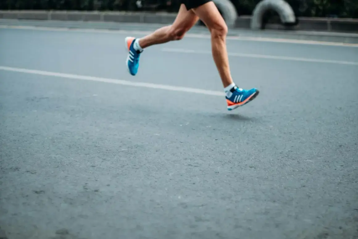 A runner's legs in motion, wearing blue and orange sneakers. This image evokes the dedication required to train, making one wonder how many miles do boxers run to achieve peak fitness.