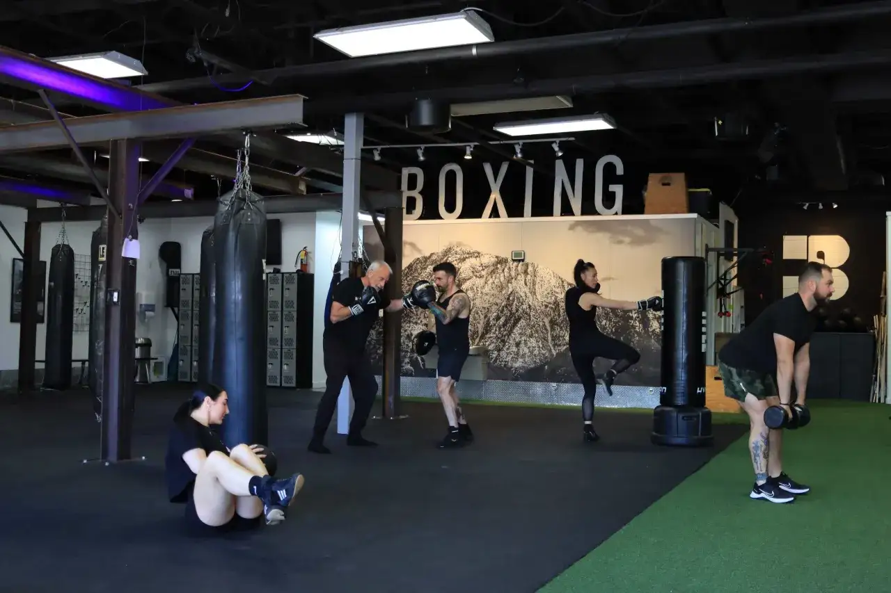 People train at a boxing gym, experiencing the full boxing benefits of strength, cardio, and discipline.